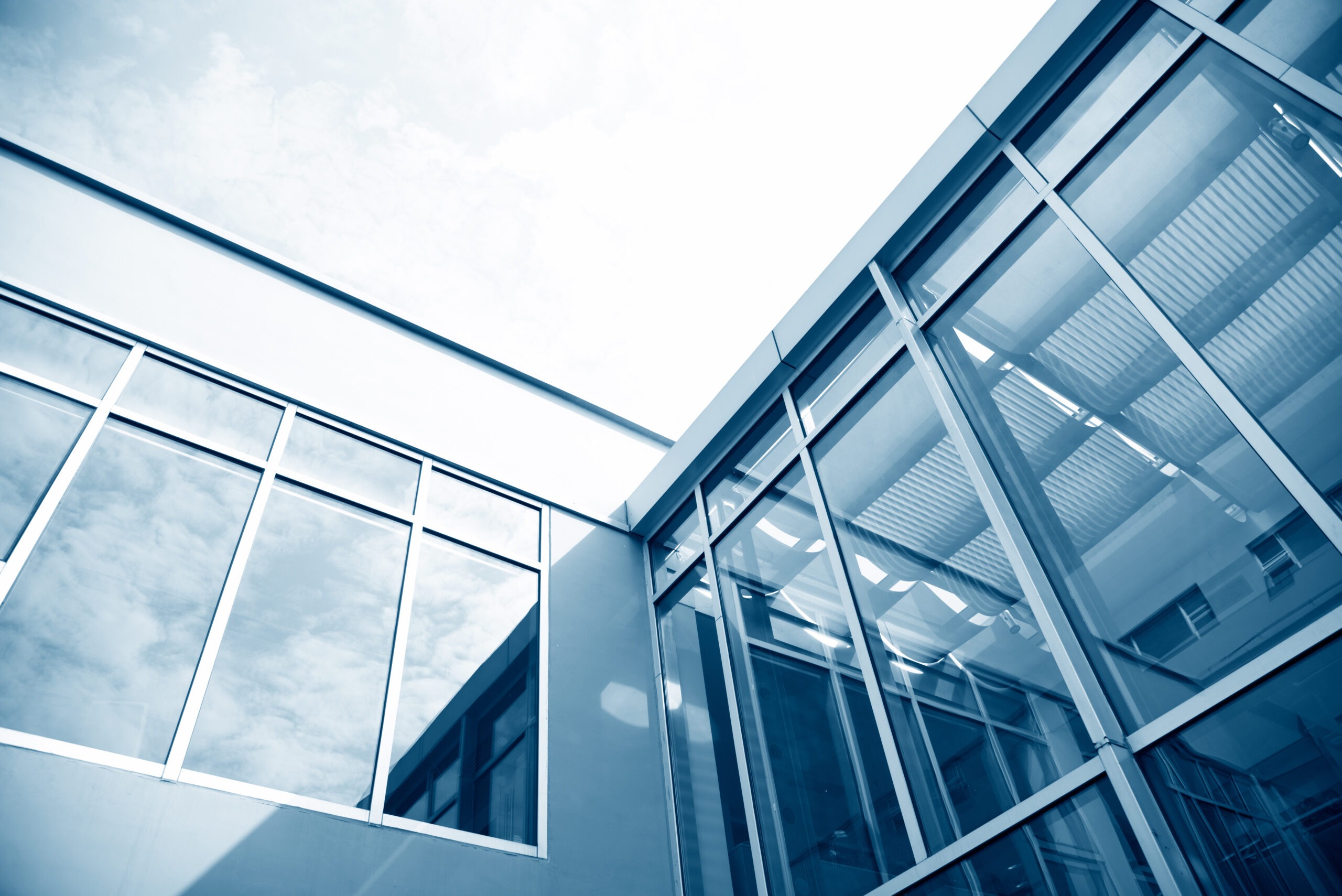 Modern glass architecture with reflections of clouds